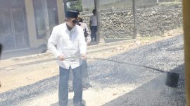 Bupati Pamekasan, KH Kholilurrahman saat bekerja bakti pengaspalan jalan bersama warga.