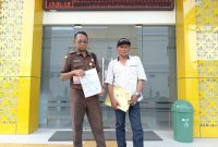 Keterangan foto: Mohammad Andra Setyabudi, SH (40), seorang Pegawai Negeri Sipil asal Bangkalan, didampingi saudaranya menunjukkan LP di depan SPKT Polres Pamekasan.