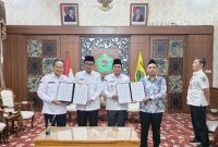 Bupati Pamekasan, KH Kholilurrahman dan Wabup Sukriyanto menunjukkan MoU penandatanganan kerjasama.