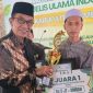 Bupati Pamekasan, KH Kholilurrahman menyerahkan piagam penghargaan kepada pemenang lomba.