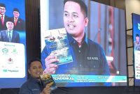 Prengki Wirananda tengah menunjukkan buku yang baru saja diluncurkan.