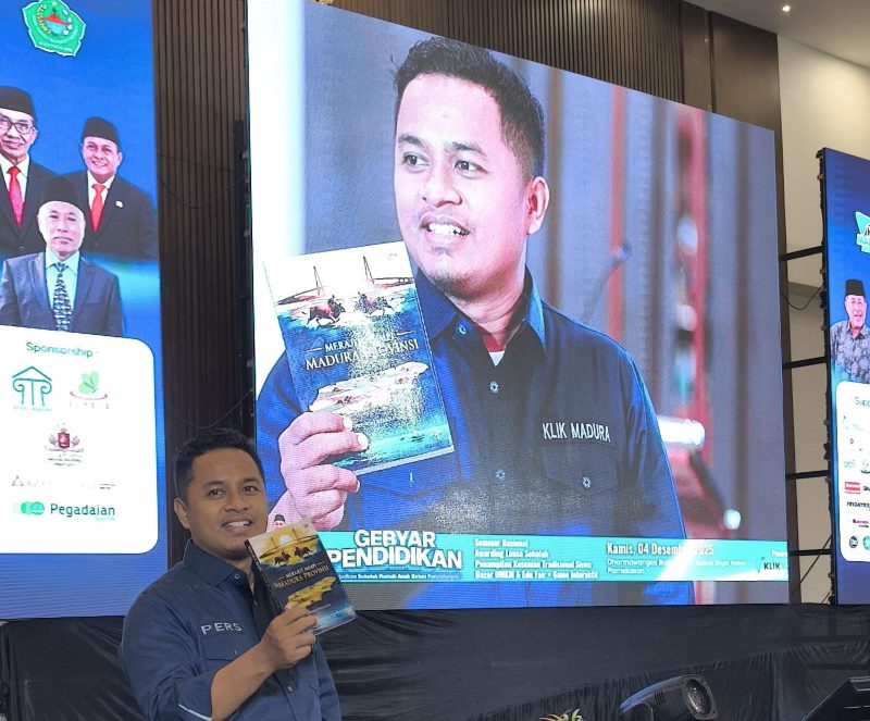 Prengki Wirananda tengah menunjukkan buku yang baru saja diluncurkan.