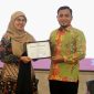 Wakil Ketua DPRD Pamekasan, H. Khairul Umam, saat menerima piagam penghargaan.