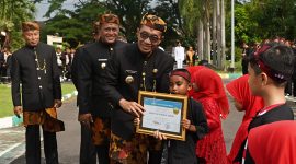 Bupati Pamekasan, KH Kholilurrahman saat memberikan piagam penghargaan kepada siswa berprestasi.