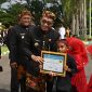 Bupati Pamekasan, KH Kholilurrahman saat memberikan piagam penghargaan kepada siswa berprestasi.